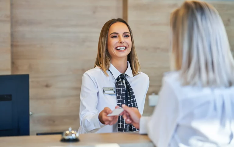 Hotel receptionist giving the key to a guest